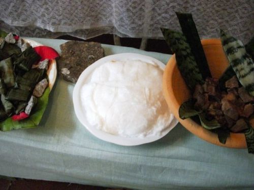 トウモロコシ料理が綿に包まれている。キリスト像に象徴されるアフリカの神様オリシャーに供えられる食べ物