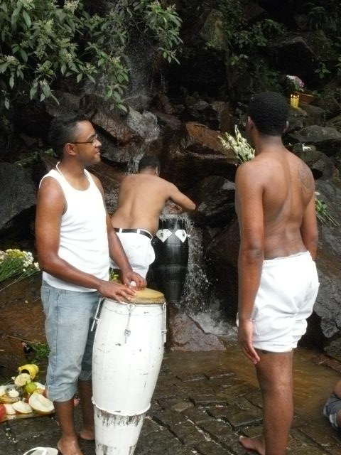 儀式で使い終えたアタバキ（太鼓）を聖なる滝で清める人