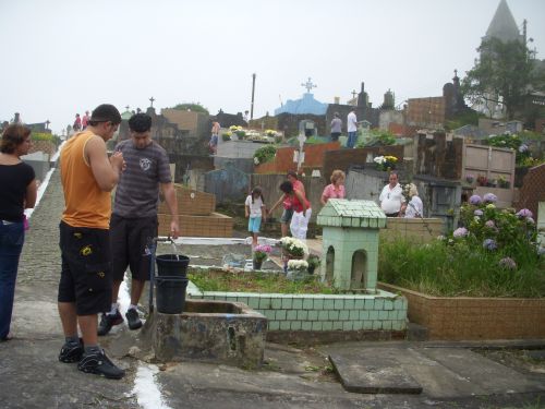 墓地で水を汲む人々