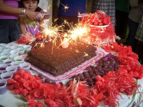 花火と6歳のロウソクの付いた誕生日ケーキとブリガデイロといわれる小さな丸い砂糖菓子