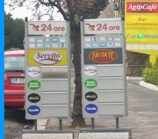 セルフサービスとサービス式の2つの料金表の看板（残念ながら月曜の朝であったのか、イタリアらしくスタンド員が忘れたのか数字表示がない！！）