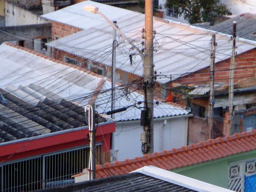 凧の尾が電信柱の左側（黒いビニール）に、赤い凧が電信柱の右側に絡み付いている