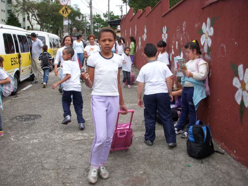 通学用カバンである小型スーツケースを運ぶ少女