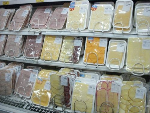 薄切りにしたハムやチーズがパッケージされて並べられている