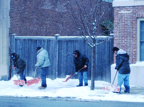 手動で雪かきをする人たち