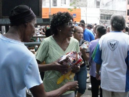 ステージの下で配られたケーキを受け取った人々