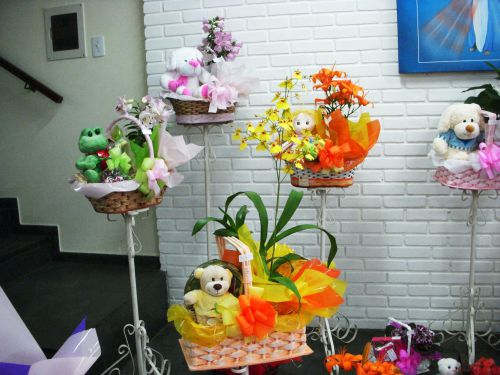花とぬいぐるみやお菓子を詰め合わせたバスケット。黄色い花はオンシジウム。