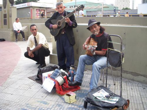 町中の通りの路上ミュージシャン。足元にはチップ入れも置かれている