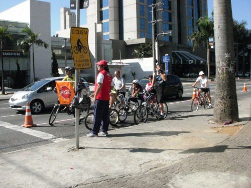 自転車に乗って車と一緒に青信号に変わるのを待つ人々