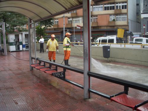 公共スペースの掃除で高水圧マシンでゴミを寄せながら水をまく人