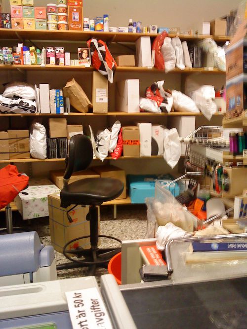 コンビニの一角に保管されている多くの小包 店員が引換証の番号と照合し小包を渡します