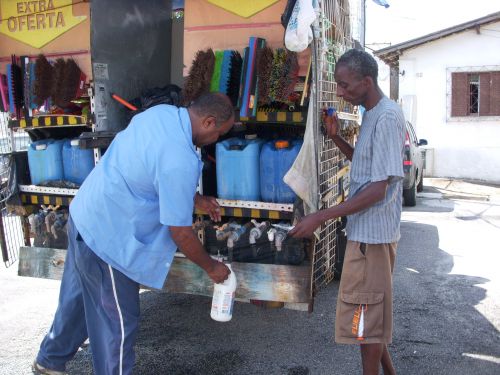 掃除用洗剤をトラックの蛇口から注いで販売する様子