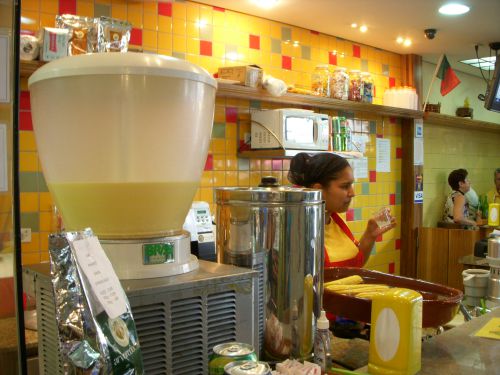 トウモロコシジュースを販売しているサンパウロ市立市場の店（右上の方にはポルトガル人がオーナーなのでポルトガル国旗が飾られています）