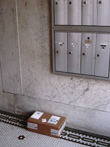 集合住宅の玄関先に置いて行かれた宅配便の荷物