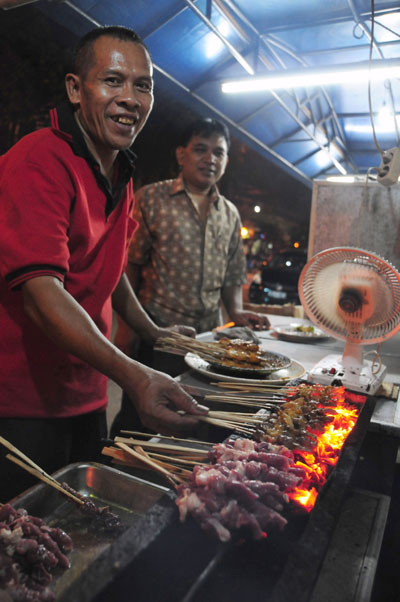 ヤギと鶏肉の串焼きを焼くおじさん。深夜２時近くまで営業しており、「休日の夜は大忙しいさ」