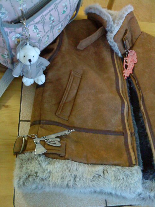 雑貨屋などに各種リフレクターが売っていますが、このように服やバッグに付けます。バッグについているクマのぬいぐるみが着ている服がリフレクターになっています。服に2つ付いているリフレクターも他にも色々な形が売られています。