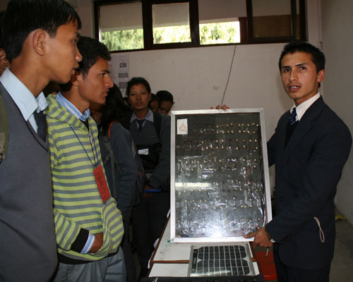 科学展で学生らを前にソーラーパネルの説明をするミランさん