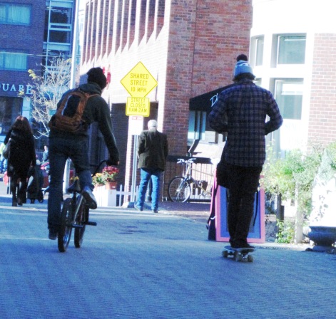 街中をスケートボードで駆け抜ける若者