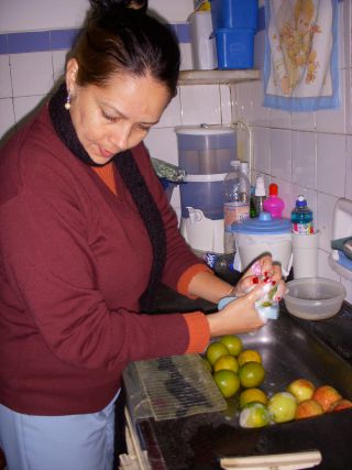 オレンジを洗剤のついたスポンジで洗うブラジルの女性
