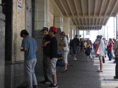 割られたガラスの代わりに取り付けた合板にメッセージを書く人たち