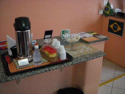 レストランのレジ近くにある無料で飲めるコーヒーの入ったポット、プラスチック容器、砂糖、お菓子など