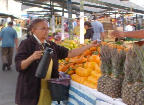 フェイラの店主にコーヒーを渡す女性