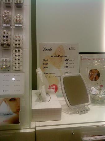 美容院の一角に並ぶ見本ピアスと料金表　アレルギー対策として、ファーストピアスの主流はやはりプラスチックやチタン製です。