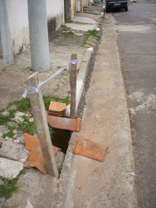 道路脇の陥没を屋根瓦で応急処置した様子（3枚目の写真は同じ場所）