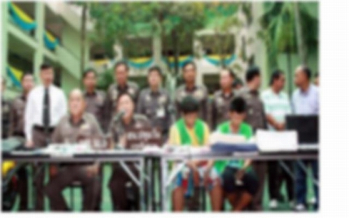 新聞に掲載されたひったくり犯2人（緑の着衣）と警察関係者（ぼかし入り）