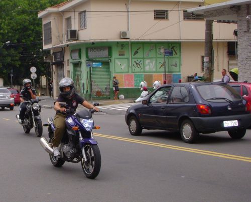 優勝後にコリンチャンスのロゴのついた服を着て警笛を鳴らしながらバイクで走るコリンチャンスファン。通りの角には警察が白バイを乗り付けて見張っている。