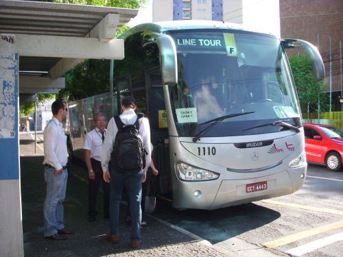 通勤のために利用される観光バスと乗車する人々