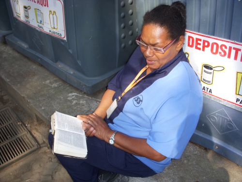 清掃作業の仕事の合間に聖書を読むブラジルの女性