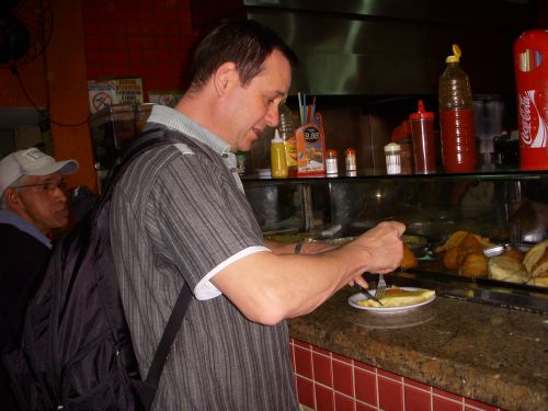 バールでナイフとフォークを使ってピザを立ち食いしていたブラジルの男性