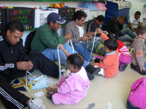 サンパウロ市内の公立保育園で平日の金曜日の午前中に開かれた父の日イベントで、凧作りをする父子たち。