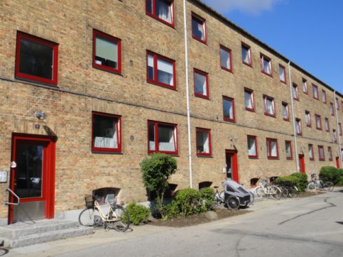 赤い窓枠で古いレンガの建物がモダンに