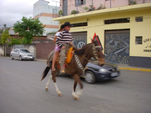 サンパウロ州サンタイザベル市の町中を馬で走る人