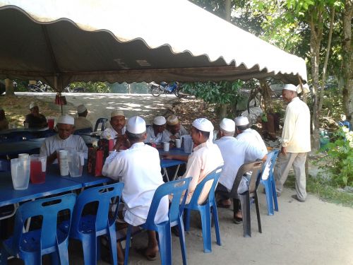 食事の支度ができる前から集まる村の男性たち。