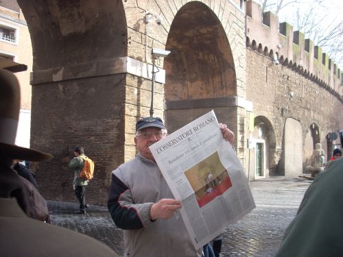 バチカン刊行新聞を購入できて満足する男性