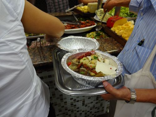 ポルキロのレストランでお持ち帰り用のパックに料理を詰めている様子