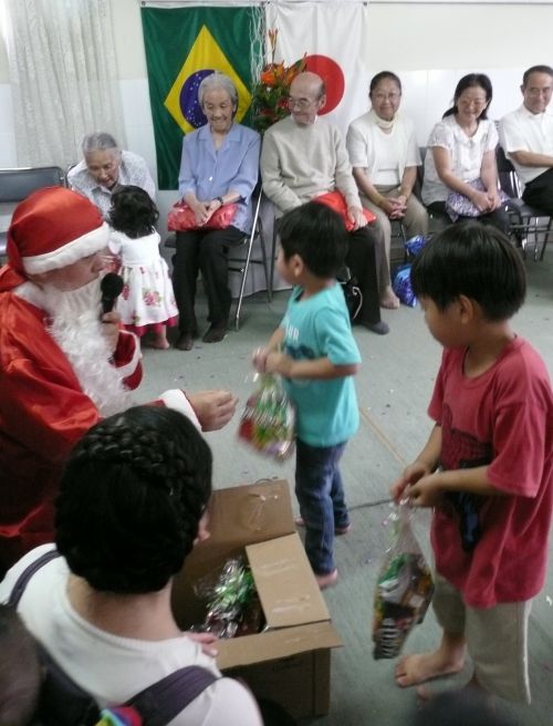 サンパウロの日系コミュニティーでサンタクロースに扮した人からプレゼントをもらう子どもたち