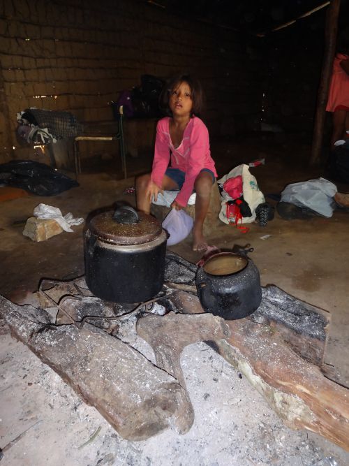 グアラニ族の少女と昔ながらの火起こしにかけた鍋