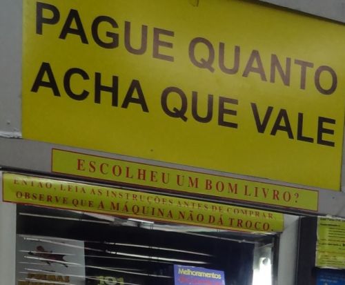 上部の大きな文字は「あなたが価値あると思うだけお金を払いなさい」、一番下の黄色い帯の中に「お釣りは出ない」と警告表示がある