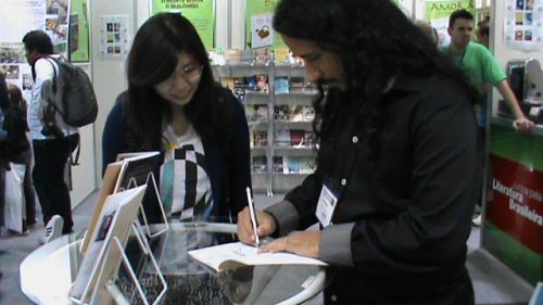 8月30、31日にサンパウロ市で開催された第23回国際図書見本市で著書にサインをするアレックスさん