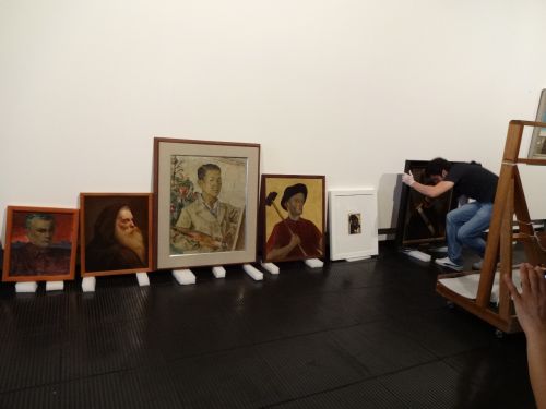 展示会を開催中に壁に飾られていく作品