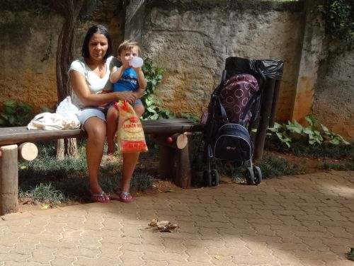 ブラジルの公園でくつろぐベビーシッターの女性と世話する子ども
