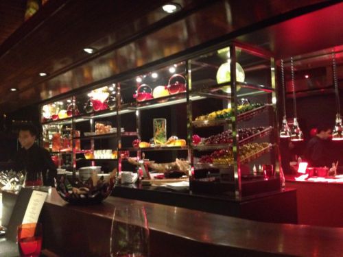 飾り棚がオープンキッチンとカウンター席のわずかなパーティションとなっている