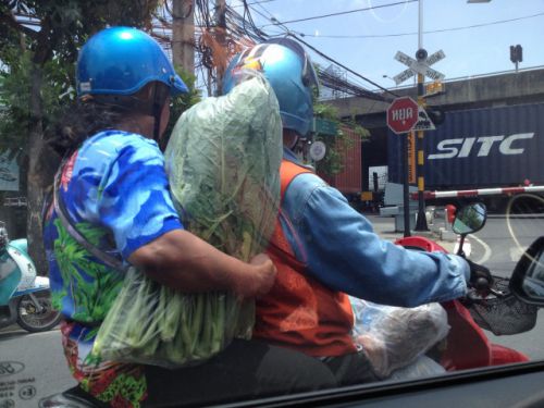 市場帰りのおばさん。バイクの前にも荷物がいっぱい