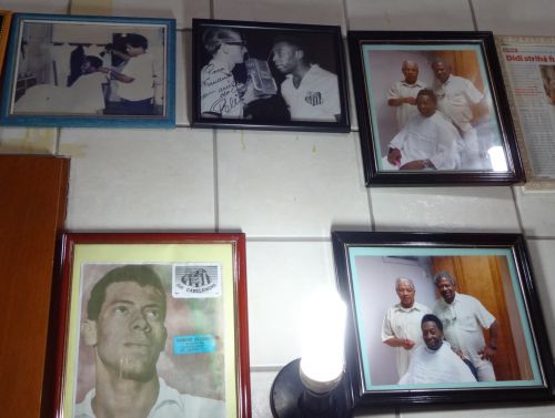 ジジさんの理髪店の店内にかけられたペレを散髪するジジさんの写真。左上は過去、右側の2枚は最近