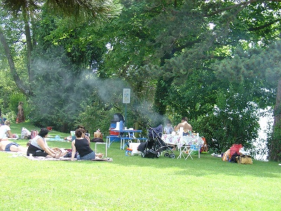 湖畔でバーベキューを楽しむ人々。