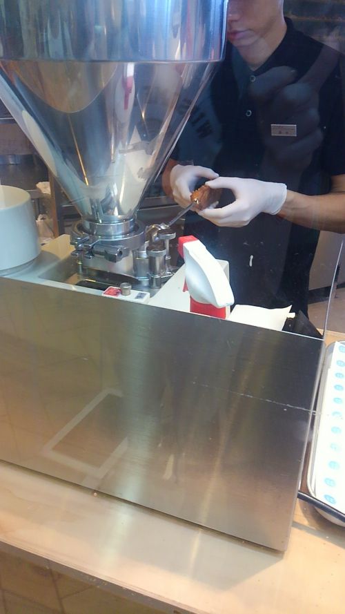 細い棒をシューに差して、クリームを注入しています。